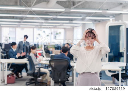 オフィスで頭を抱える女性従業員 127889539