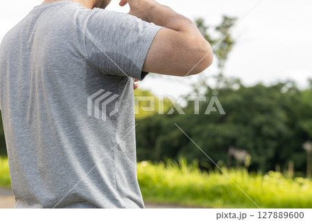 グレーのティーシャツを着た汗だくの中年男性 127889600
