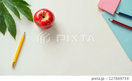 A collection of school supplies and an alarm clock arranged on a vibrant white background, symbolizing a school setting 127889739