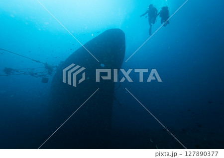 Two Divers Explores the Relax Wreck at Dive Site on the Island of Bali, Indonesia. Two Divers Explores the Relax Wreck at Dive Site on the Island of Bali, Indonesia. 127890377