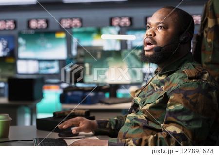 Military officer in command post having shocked look on face after receiving intel on enemy battle formation. Intelligence specialist feeling gutted after learning of incoming missiles attack 127891628