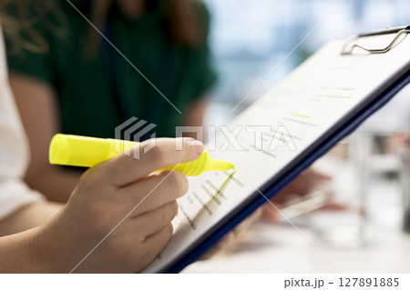 HR expert negotiating job offers and salary packages with candidate, highlighting text on document. Recruiter analyzing applicant resume and cover letter, using highlighter marker 127891885