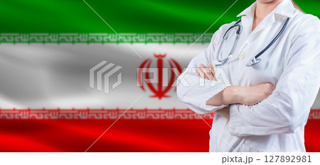 Doctor with crossed arms on Iran flag. Iran health and care concept. Female doctor on Iran flag Doctor with crossed arms on Iran flag. Iran health and care concept. Female doctor on Iran flag 127892981