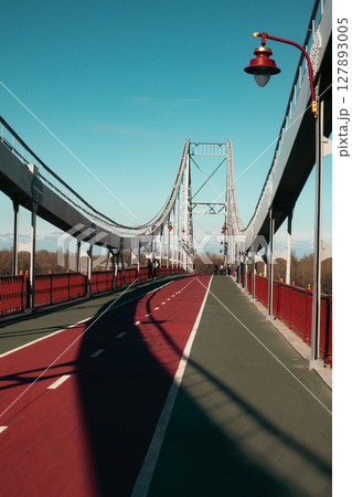 Suspension Pedestrian Bridge with Bicycle Lane under Clear Blue Sky Suspension Pedestrian Bridge with Bicycle Lane under Clear Blue Sky 127893005