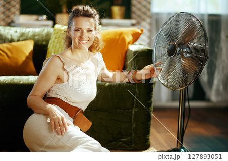 Summer Comfort: Smiling Woman with Fan Summer Comfort: Smiling Woman with Fan 127893051