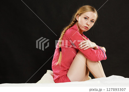 Sad young teenager woman sitting on bed 127893307