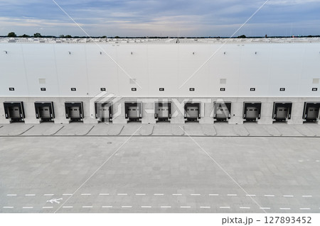 Logistics warehouse exterior with loading platforms, aerial view 127893452