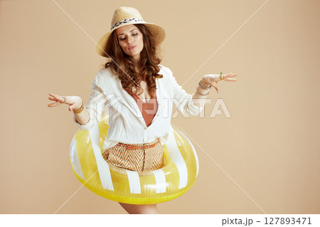 happy stylish woman in blouse and shorts on beige 127893471