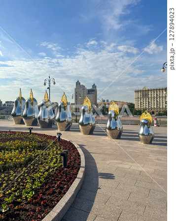 Colorful sculptures line a city walkway in bright sunlight 127894023