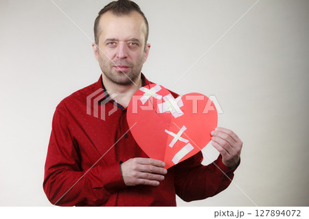 Sad adult man holding broken heart Sad adult man holding broken heart 127894072