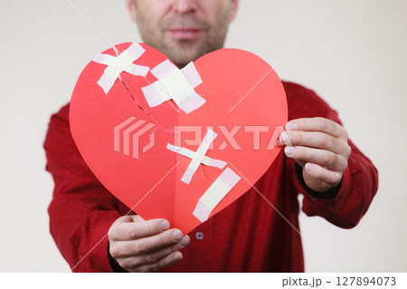 Man holding broken heart. Heartbreak Man holding broken heart. Heartbreak 127894073