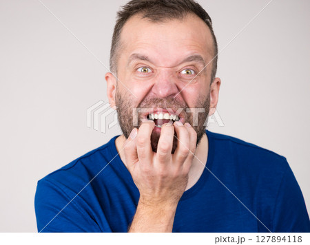 Man biting his nails 127894118