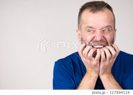 Man biting his nails Man biting his nails 127894119