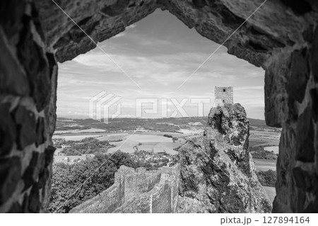 Visitors enjoy breathtaking vistas from the historic Trosky Castle ruins in Bohemian Paradise, Czechia. The structure rests atop a rock formation, offering expansive views of the landscape. 127894164
