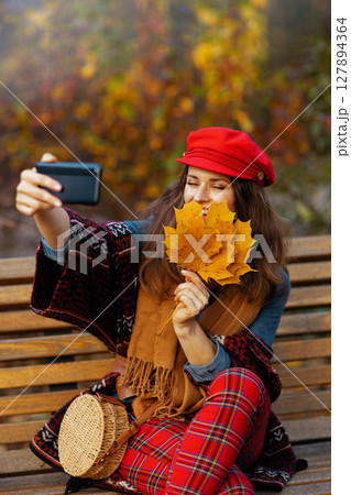 woman having online meeting while sitting on bench in city park woman having online meeting while sitting on bench in city park 127894364