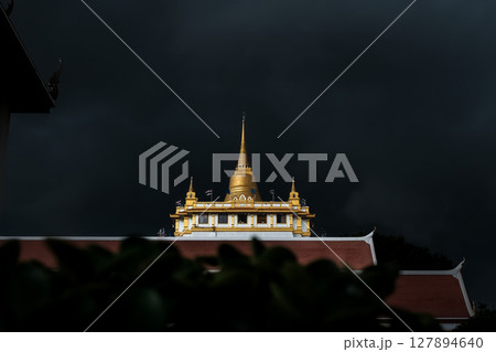 Golden mountain in Wat Saket Bangkok Thailand covered with dark rain clouds at the top looks scary before the rain falls. 127894640