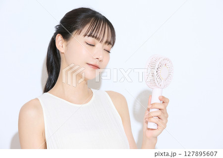 暑さ対策をする若い女性のポートレート 127895607