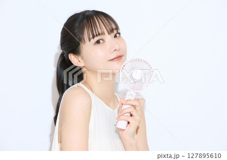 暑さ対策をする若い女性のポートレート 127895610