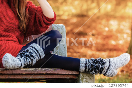Autumn fashion. Female legs in warm socks outdoor 127895744