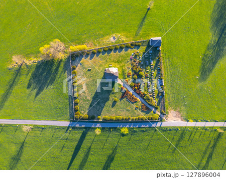 The serene Tesarov Chapel stands surrounded by a quaint graveyard, nestled in the lush green landscape of Korenov. A beautiful aerial perspective showcases this peaceful site in the Jizera Mountains. The serene Tesarov Chapel stands surrounded by a quaint graveyard, nestled in the lush green landscape of Korenov. A beautiful aerial perspective showcases this peaceful site in the Jizera Mountains. 127896004