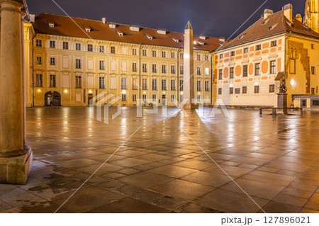 The Mrakotin Monolith stands tall in the courtyard of Prague Castle, surrounded by historic buildings. Soft lamp light reflects off the wet cobblestones, creating a serene nighttime atmosphere. The Mrakotin Monolith stands tall in the courtyard of Prague Castle, surrounded by historic buildings. Soft lamp light reflects off the wet cobblestones, creating a serene nighttime atmosphere. 127896021