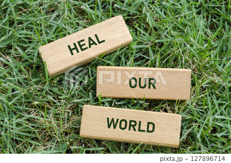 Heal Our World text on wooden blocks, symbolizing a hopeful message to restore environmental balance. Earth recovery concept Heal Our World text on wooden blocks, symbolizing a hopeful message to restore environmental balance. Earth recovery concept 127896714