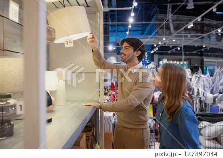 Young couple actively exploring various trendy lighting options in contemporary furniture store Young couple actively exploring various trendy lighting options in contemporary furniture store 127897034