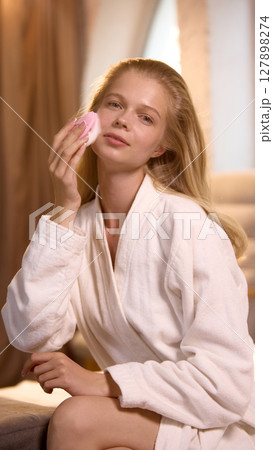 Beauty-tech. Woman uses sonic brush, side profile with foaming gel. Beauty-tech. Woman uses sonic brush, side profile with foaming gel. 127898274