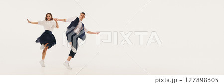 Dynamic duo performing lindy hop dance with lively retro flair against minimalist backdrop. Banner Dynamic duo performing lindy hop dance with lively retro flair against minimalist backdrop. Banner 127898305