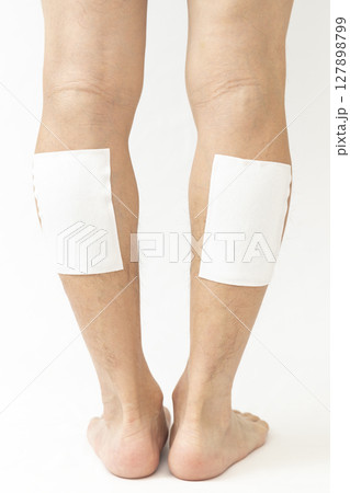 湿布を貼った男性の脚 白バック 湿布を貼った男性の脚 白バック 127898799