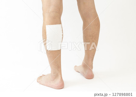 湿布を貼った男性の脚　白バック 127898801