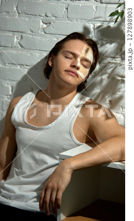 Natural beauty. Clay mask covers half the young man face, dramatic texture in detail. 127898903