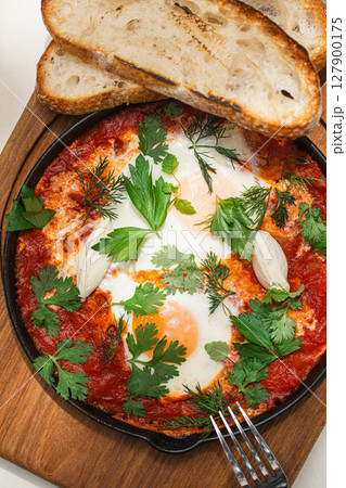 Portion of shakshuka breakfast with eggs 127900175