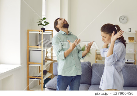 Upset young couple quarreling in the living room at home. Relationship and divorce concept. 127900456