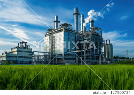 Modern gas power plant is operating near a green field, highlighting the contrast between industrial activity and the environment 127900724