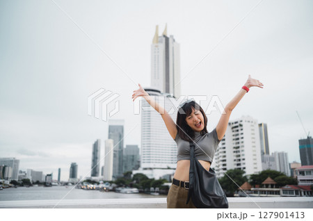 Happy solo young southeast asian woman teenager blogger world travel explorer with smartphone. local cultural tourism experience concept by Chao Phraya river in Bangkok Asia Thailand 127901413