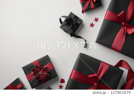 Black friday composition with gift boxes wrapped in black paper and tied with red ribbons on white background with copy space 127901679