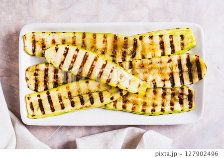 Close up of grilled zucchini slices on a plate  on the table top view 127902496