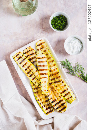 Delicious grilled vegetable zucchini on a plate on the table top and vertical view 127902497