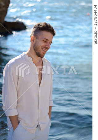 A Smiling Man by the Seaside Enjoying the Warmth of Natural Light on a Beautiful Day A Smiling Man by the Seaside Enjoying the Warmth of Natural Light on a Beautiful Day 127904434