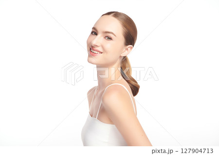 A beautiful young woman with clean, fresh skin against a white background. Skincare, facial treatment, cosmetology, beauty, and spa. An elegant portrait of an woman. 127904713