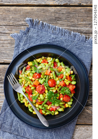 succotash of corn, beans, tomatoes, in black bowl 127904848