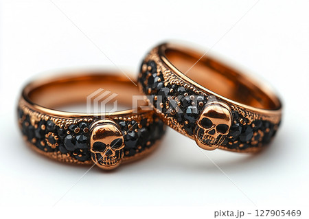 Pair of gold wedding rings with a skull pattern on a white background. Original style. Pair of gold wedding rings with a skull pattern on a white background. Original style. 127905469