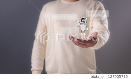A person holding their hand out with a miniature white robot displaying AI and chat bubbles, Artificial intelligence, conversational AI, digital assistance, future technological interaction. A person holding their hand out with a miniature white robot displaying AI and chat bubbles, Artificial intelligence, conversational AI, digital assistance, future technological interaction. 127905786