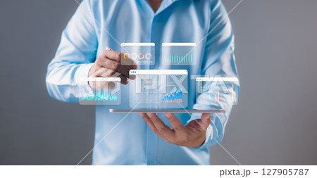 Businessman using a stylus to analyze interactive data dashboards on digital tablet screen. Data analytics, business intelligence, technology solutions, financial performance, Real-time visualization. Businessman using a stylus to analyze interactive data dashboards on digital tablet screen. Data analytics, business intelligence, technology solutions, financial performance, Real-time visualization. 127905787