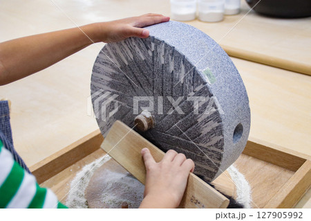 石臼の蕎麦粉を掻き出す子供（7歳児／男の子） 127905992