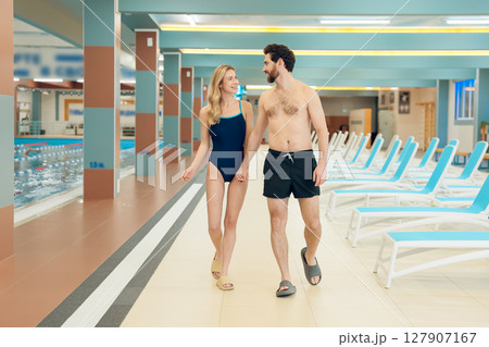 Young cute couple in swimwear in the swimming pool 127907167
