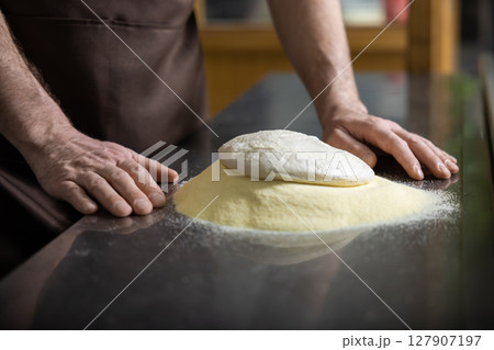 Close up of mans hands kneading dough for preparing pizza Close up of mans hands kneading dough for preparing pizza 127907197