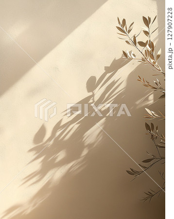Shadows cast by delicate leaves create a serene atmosphere on a warm-toned wall Shadows cast by delicate leaves create a serene atmosphere on a warm-toned wall 127907228