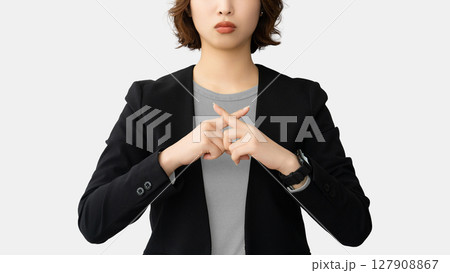 指でバツのポーズをする困った表情の女性 127908867